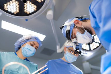 Steril ameliyat ekibi. Yüzü maskeli ve üniformalı..