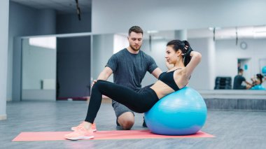 Erkek ve Kadın Egzersiz Topları Üzerinde Egzersiz Yapıyor. Bir erkek ve bir kadın, çeşitli egzersizleri gerçekleştirmek için egzersiz toplarını kullanırlar..