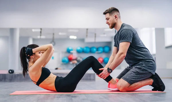 Man and Woman Performing Plank Exercise Together. A man and a woman demonstrate proper form and teamwork while doing the plank exercise.