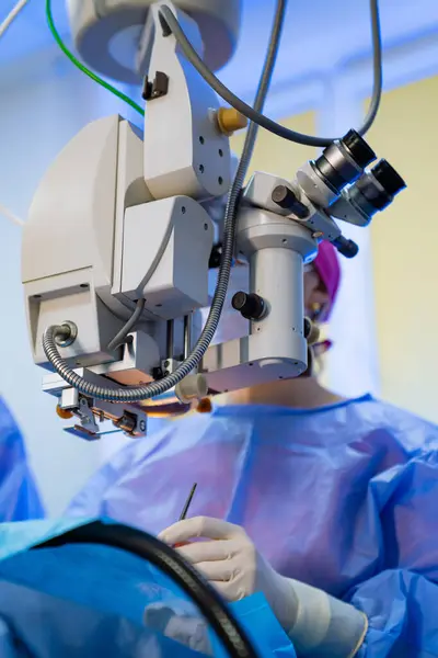 Surgeon is operating robotic surgery machine in hospital.