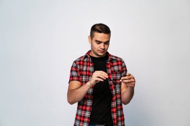 Beyaz arka planda izole edilmiş cep telefonu kullanan genç adamın portresi