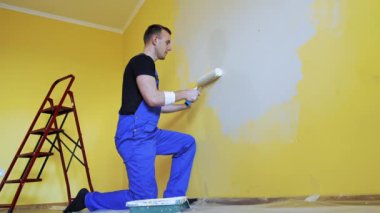 Odayı tamir eden profesyonel bir tamirci. Yakışıklı boyacı oda tadilatı yapıyor..