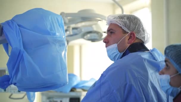 手術ハンサムドクターが病院で働いています 緊急区の検事と協力する集中外科医 — ストック動画