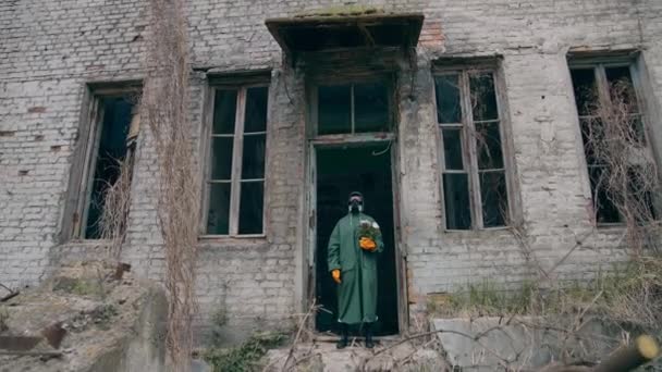 植物のバイオハザードスーツの男 破壊された都市に立っている保護スーツの人 — ストック動画