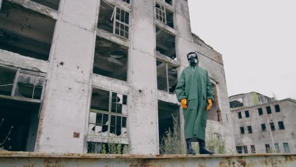 破壊された都市に立っている保護スーツの人 バイオハザードスーツの男 — ストック動画