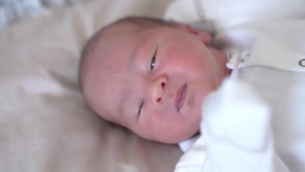 白い毛布の上に置かれている美しい小さな新生児 軽い布で小さなかわいい赤ちゃんのクローズアップビュー — ストック動画