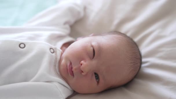 Κοντινό Νεογέννητο Μωρό Άσπρα Ρούχα Μωρό Μια Ελαφριά Μπλούζα Ξυπνά — Αρχείο Βίντεο