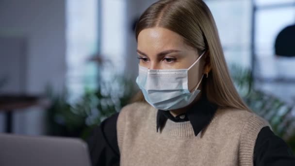 コンピュータで働くマスクの若い女性 マスクのポートレート検疫の従業員 — ストック動画