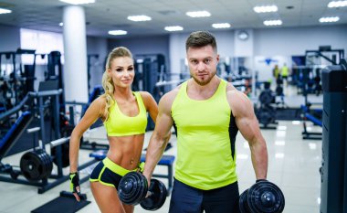 Spor salonunda halterli bir erkek ve kadın..