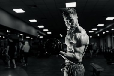 Spor salonunda kameraya poz veren kaslı yakışıklı adam Standard-Bild