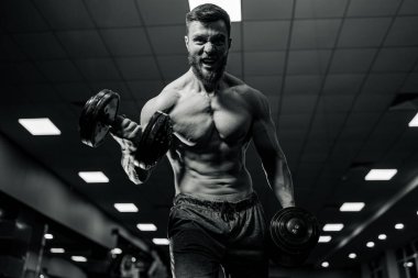 Spor salonunda kameraya poz veren kaslı yakışıklı adam Standard-Bild