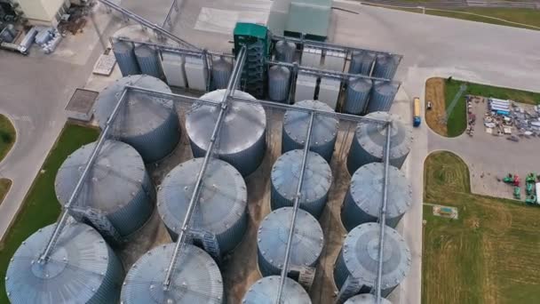 現代工場の列に立っているサイロ鋼タンク 農業事業におけるハンガー トラックの航空展望 — ストック動画