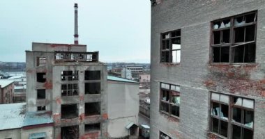 Geçmişteki büyük santrallerin yıkıntıları. Terk edilmiş, penceresi ve eski tuğla duvarları olmayan boş binalar. Arkaplanda mavi açık gökyüzü.