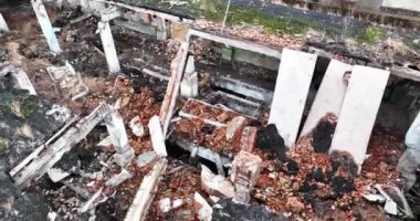 Çatısı ve penceresi olmayan tamamen harap bir bina. Silahlı çatışmadan sonra etrafa saçılan tuğlalar, kirişler ve beton parçaları. Hava görünümü.
