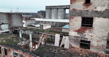Bombalanan binalarda çıplak tuğla duvarlar ve pencere delikleri. Hava saldırısından kaynaklanan yıkılmış mimari. İHA atışı.