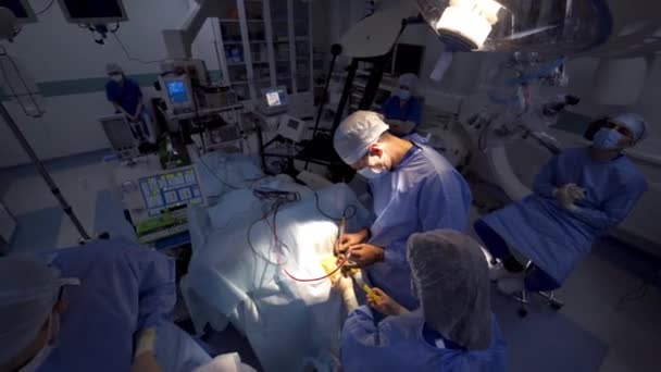 手術を行う外科専門家を協力する 近代的な技術機器を備えた大規模なオペレーションルーム 上からの眺め — ストック動画