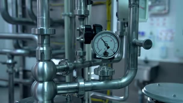 金属タンクにつながる圧力計が付いている鋼管 近代的な乳製品工場で装備しています クローズアップ — ストック動画