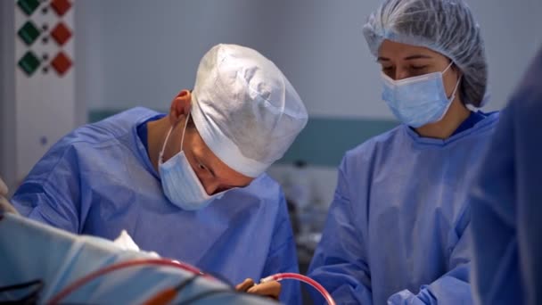 Cirurgiões Concentraram Cirurgia Médico Masculino Assistente Feminino Máscaras Continuam Operação — Vídeo de Stock
