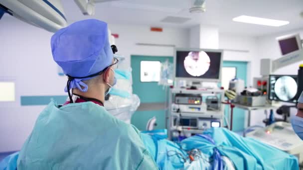 Surgeon Applies Instruments Operation Male Doctor Watches Run Operation Screen — Stock Video