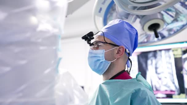 Chirurg Specjalnym Urządzeniem Głowie Stoi Sali Operacyjnej Lekarz Trzyma Instrument — Wideo stockowe