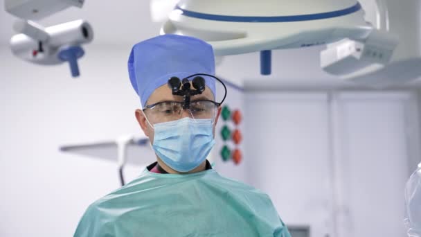 若い男性外科医は現代の病院で手術を行っています 職場の医療専門家の肖像画を閉じる — ストック動画