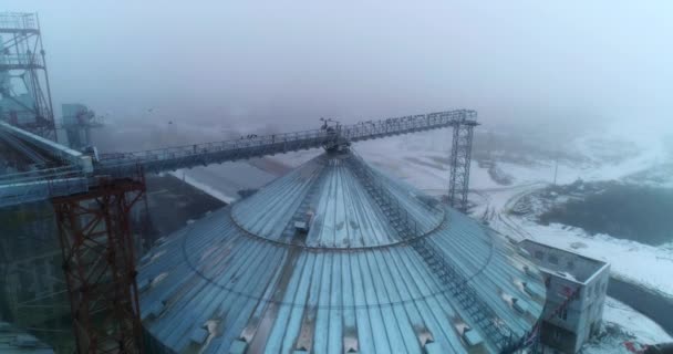 上から収納エレベーター タンクの上に金属製のビームに鳥が集まっている 背景にある冬の霧の風景 — ストック動画