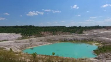 Kaolin taş ocağının güzel manzarası. Derin kil madeni suyla dolu. Göletten yansıyan mavi gökyüzü.