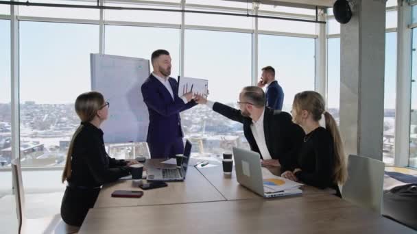 コワーカーのチームは 彼らのチーフの手でチャートを議論しています オフィス雰囲気での積極的なコラボレーション バックドロップで電話で話す男性のビジネスマン — ストック動画