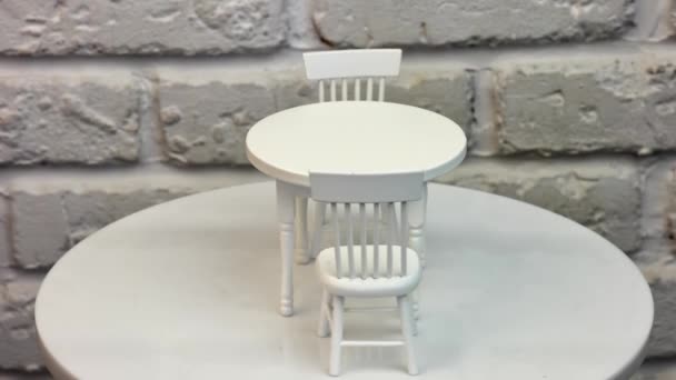 玩具圆桌和旁边的两张小椅子 旋转桌旁漂亮的洋娃娃家具 白墙背景 — 图库视频影像