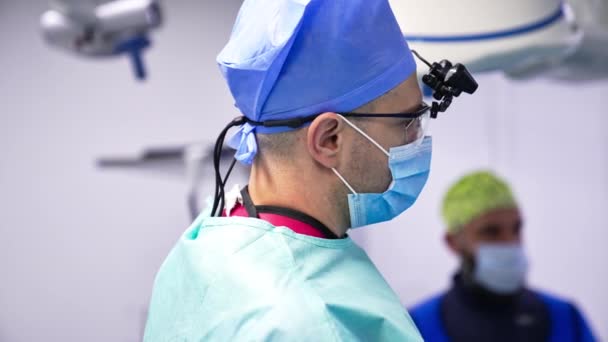 操作の準備ができた保護衣装の中年外科医 手術室の病院スペシャリストの肖像画 バックグラウンド — ストック動画