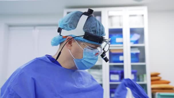 男主治医生将外科手术器械输送到病人的鼻子里 专家在屏幕上监视他的行动 助手把工具交给医生 — 图库视频影像