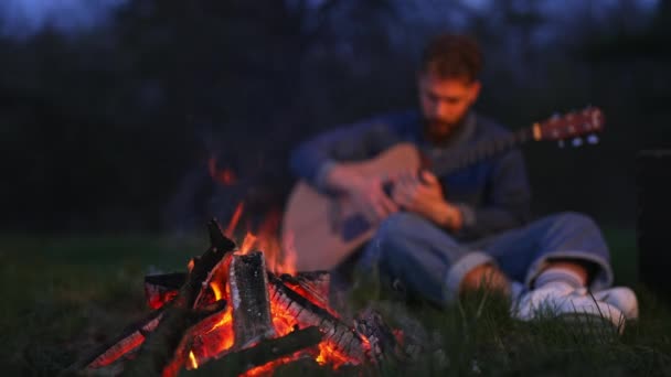 Hoguera Ardiendo Campamento Bosque Joven Sentado Junto Fuego Sosteniendo Guitarra — Vídeos de Stock
