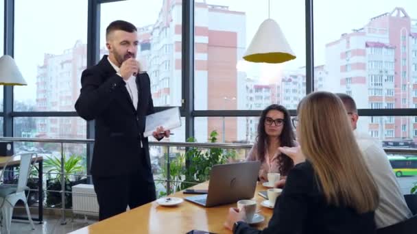 オフィスチームはコーヒーを飲んで作業の問題について話し合う パノラマ窓のある居心地の良いオフィスでのコラボレーションとチームワーク — ストック動画