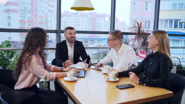 Adamları Kahve Fincanındaki Çalışma Anlarını Tartışıyor Takım Elbiseli Adam Merkezde — Stok video