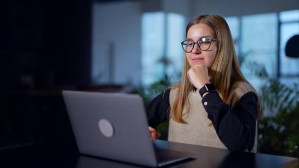机に座ってノートパソコンで何かを印刷する若いビジネスレディ 女性は笑顔で 彼女の頭を承認した バックグラウンド — ストック動画