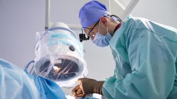 手術器具を保持するゴム手袋の医療専門家 手術終了時に手術現場を縫う外科医 ローアングルビュー — ストック動画