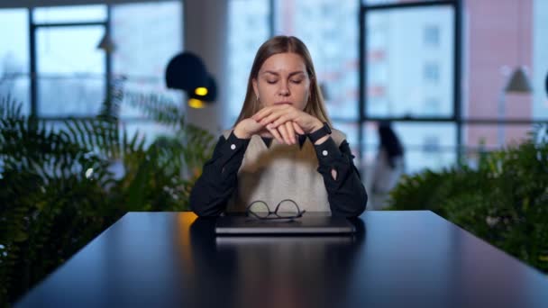 Młoda Zmęczona Kobieta Siedzi Przy Stole Zamkniętym Laptopem Przed Sobą — Wideo stockowe