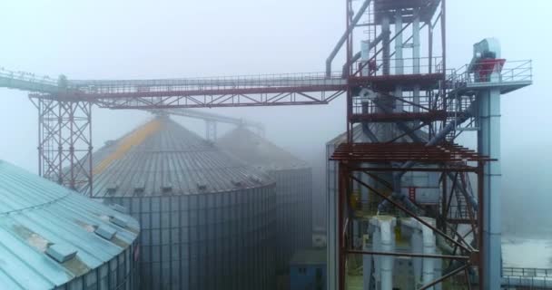 冬季多雾的天气里 强大的农业植物出现在室外 金属支撑连接电梯的储罐 无人机画面 — 图库视频影像