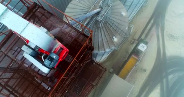 近代的なエレベーター工場の巨大な容器 装置が付いているタンクおよび金属タワーの上のドローン映像 貯蔵に穀物を荷を下ろすローリーのトップビュー — ストック動画