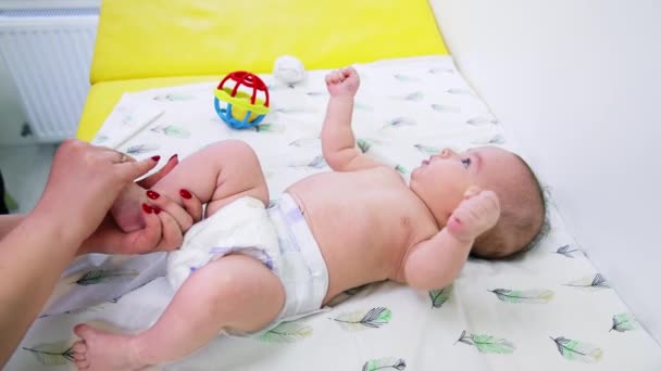 Kinderärztin Hält Babyfuß Den Händen Und Dreht Ihn Ihn Kontrollieren — Stockvideo