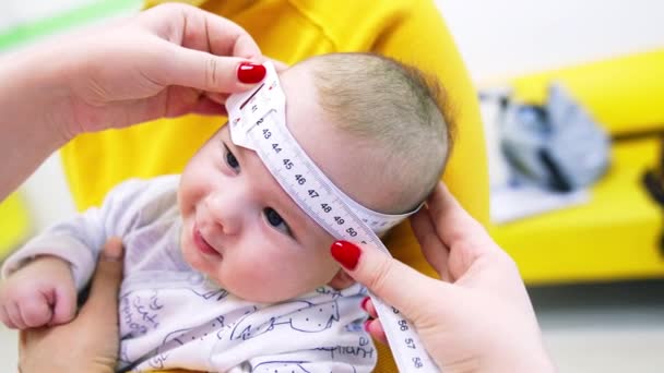 Παιδίατρος Παίρνει Μέγεθος Του Κεφαλιού Του Μωρού Μεζούρα Ενώ Μαμά — Αρχείο Βίντεο