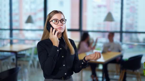 戴眼镜的女人在手机上交谈 她讲话结束时不满意 女雇员再拨一次号码 — 图库视频影像