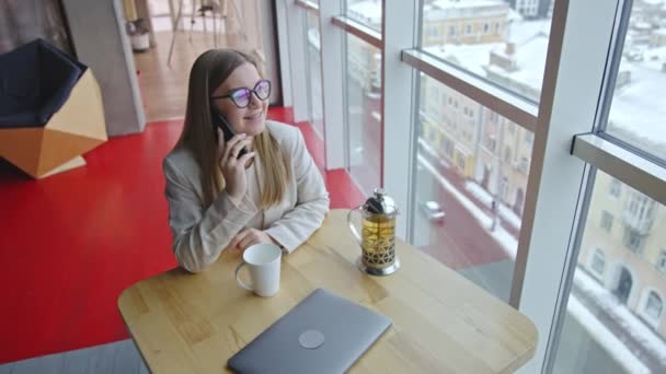 オフィスで紅茶を飲むライトスーツを着ている女性 ランチ休憩中に電話で話すビジネスマン 高角度ビュー — ストック動画