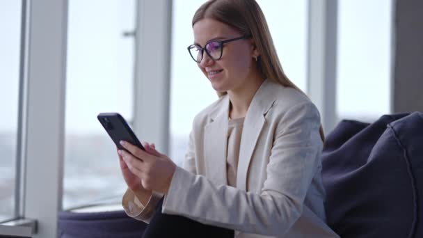 Gyönyörű Fiatal Hölgy Szemüvegben Információt Keres Telefonban Ránéz Laptopjára Aztán — Stock videók