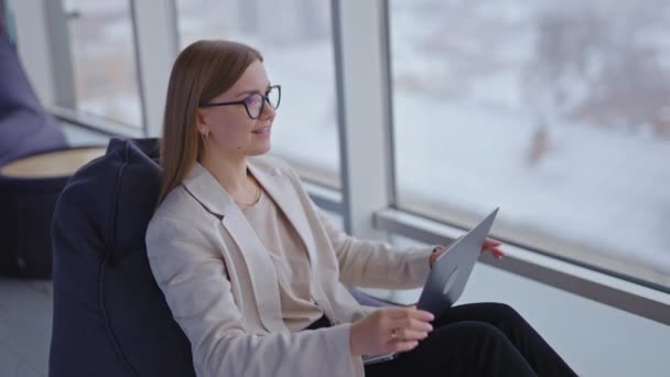 Przyjemna Kobieta Siedząca Krześle Laptopem Nogach Uśmiechnięta Dama Kończy Pracę — Wideo stockowe