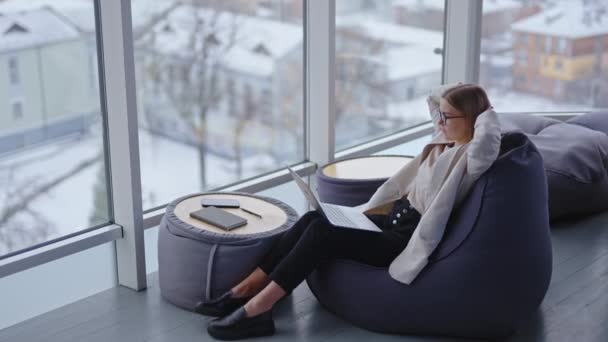 Kodikas Työpaikka Modernissa Toimistossa Nainen Istuu Paputuolin Ääressä Työskentelee Kannettavalla — kuvapankkivideo