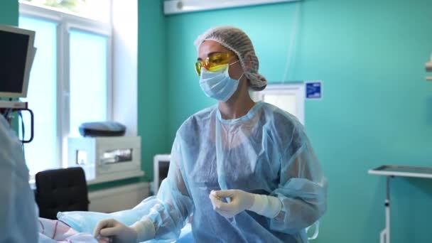 Hastane Operasyon Odasındaki Yardım Personeli Koruyucu Kıyafetli Gözlüklü Bir Hemşire — Stok video