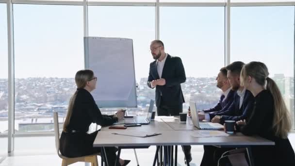 オフィスで会議で議論しているビジネスマン 中年男性マネージャーが同僚のプレゼンテーションを行います — ストック動画