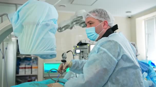 집중적이고 신중한 외과의사는 환자에 장치를 보유하고 있습니다 의사는 조수에게 무언가를 — 비디오