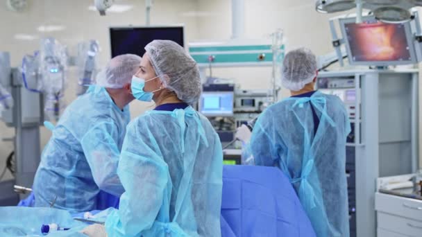 Zespół Medyczny Operujący Pacjenta Obserwujący Proces Ekranie Chirurdzy Stosujący Urządzenie — Wideo stockowe